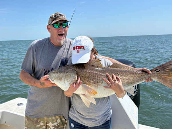 Gecko charter customers holding large red drum.Spring Has Sprung