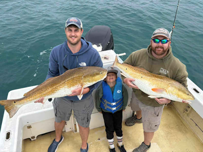 Ocracoke anglers with two big red drum.