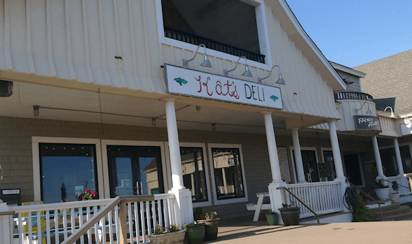 Exterior of Kati Deli the building has a light tan facade with white pillars.